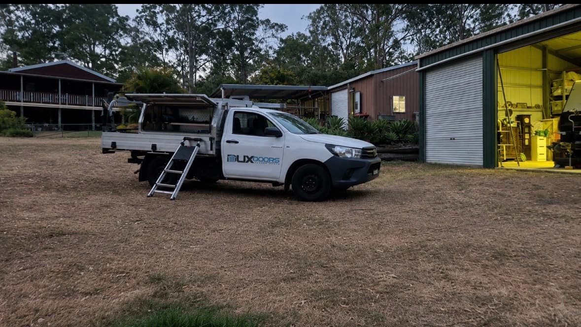 DuxDoors service ute parked outside a workshop with roller doors
